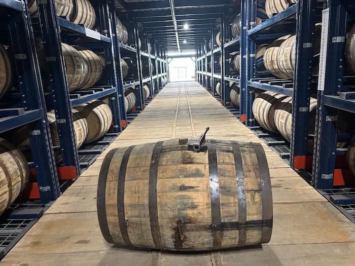 A barrel resting in the aisle of a bonded rickhouse
